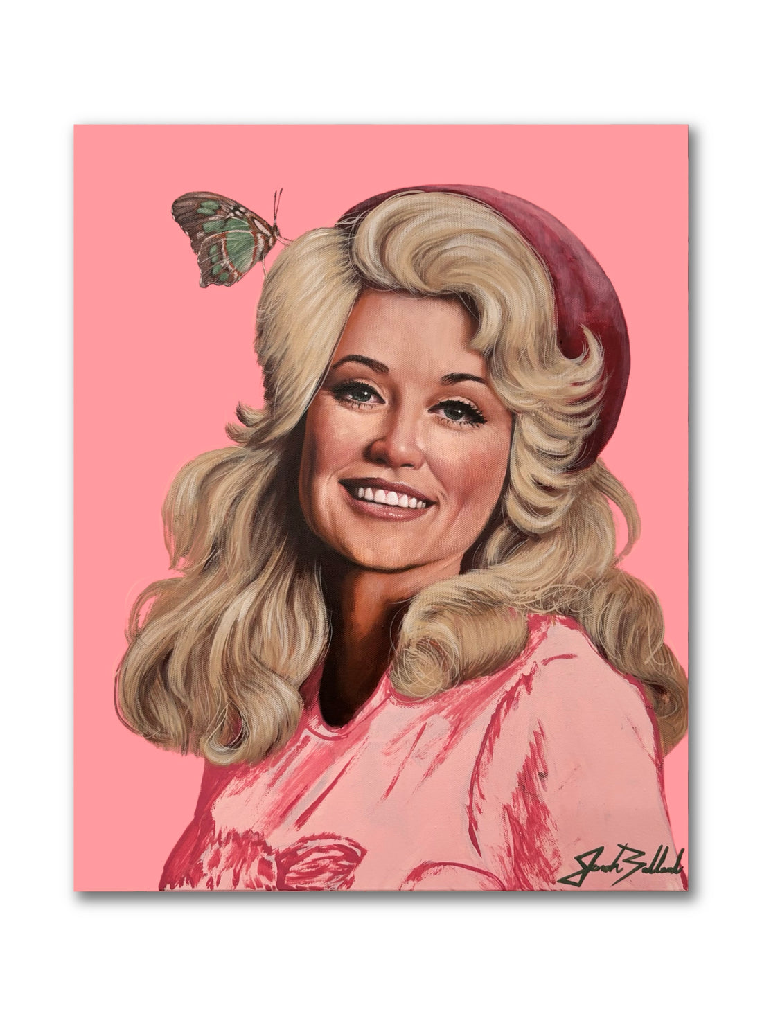 A paper print of Dolly Parton featuring an illustration of her with a pink background, wearing a red hat and a smile on her face. A butterfly is also depicted in the top right corner.