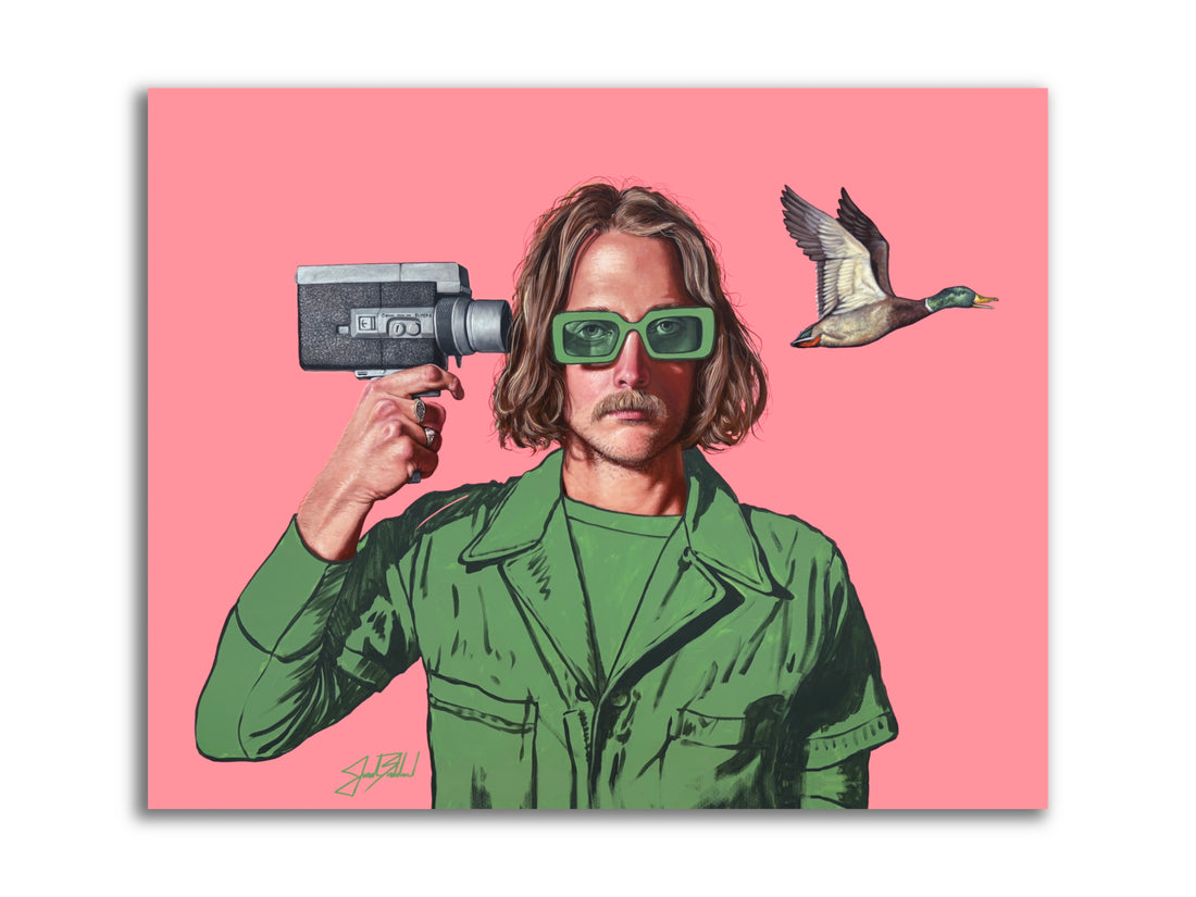 A colorful paper print of a person wearing green clothing and sunglasses, holding a video camera, with a flying duck in the background.