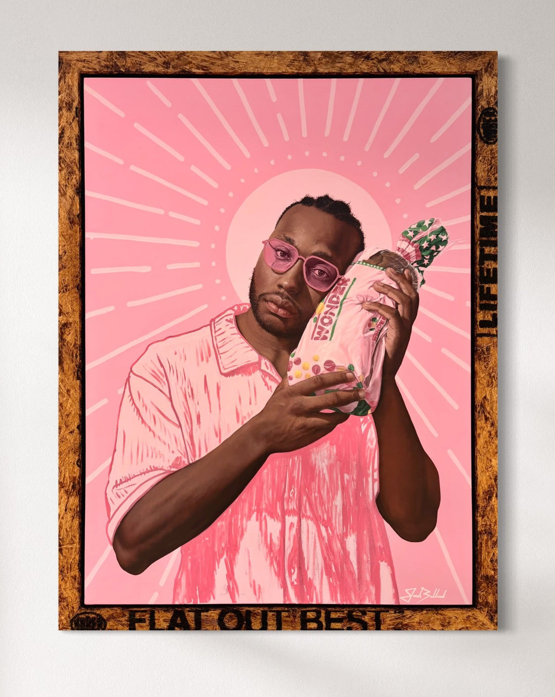 Framed artwork of a man holding a bag labeled "Wonder", with a pink background in a living room setting.