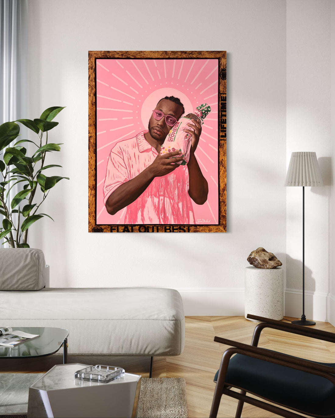 Framed artwork of a man holding a bag labeled &quot;Wonder&quot;, with a pink background in a living room setting.